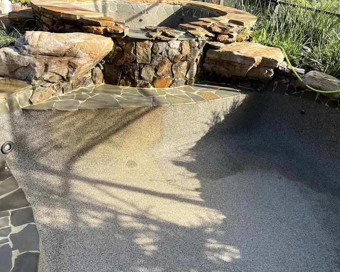 Screened backyard pool drained and cleaned during a green pool turnaround